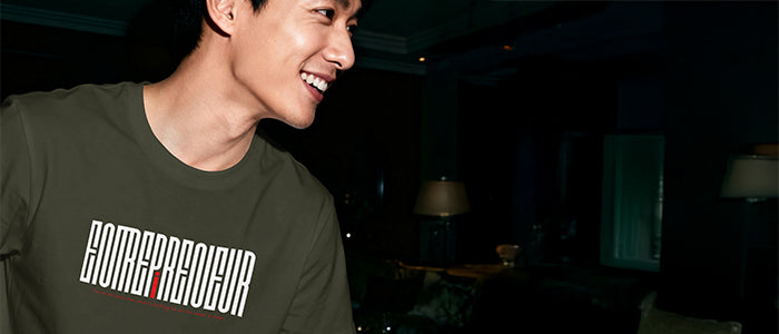 Man wearing a t-shirt with text in a dark indoor setting